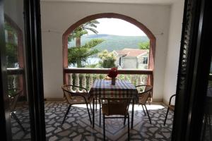 a table and chairs in a room with a window at Apartments Roza in Herceg-Novi