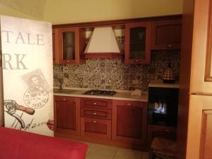 a kitchen with wooden cabinets and a stove top oven at Sogni d'Oro in Grottaglie