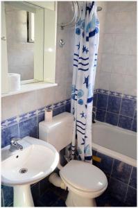 a bathroom with a toilet and a sink and a shower curtain at Apartments Roza in Herceg-Novi +62 photos