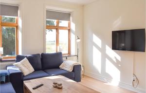 トメリラにある6 Bedroom Gorgeous Home In Tomelillaのリビングルーム(青いソファ、テレビ付)