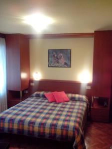 um quarto com uma cama com duas almofadas vermelhas em Hotel Monte Fior em Foza