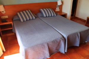 a bed with two pillows on it in a room at Hotel Picasso in Torroella de Montgrí