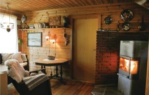トベーデストランにあるLovely Home In Tvedestrand With House Sea Viewの暖炉とテーブルが備わるレンガの壁の客室です。