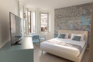 una camera con letto e scrivania con TV di Casa Jaume ad Alghero