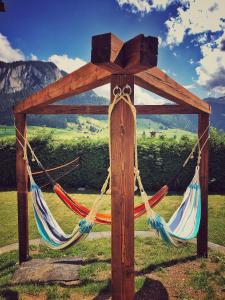 a couple of hammocks tied to a wooden structure at Family B&B Le Vieux Chalet in Chateau-d'Oex