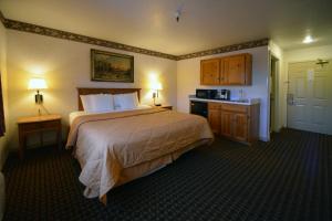 a hotel room with a bed and a kitchen at Cherry Orchard Inn in Sunnyvale