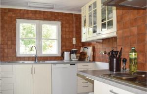 a kitchen with white cabinets and a window at Amazing Home In Bolmsö With Lake View in Bolmstad