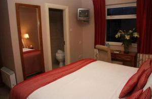 キラーニーにあるLake Lodge Guesthouseのベッドとバスルーム付きのホテルルームです。