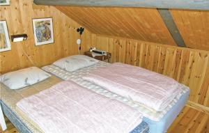 ein Schlafzimmer mit einem Bett in einer Holzwand in der Unterkunft Lovely Home In Trans With Kitchen in Sundhultsbrunn