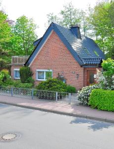 a red brick house with a black roof at Appartement Am Schulwald in Büsum