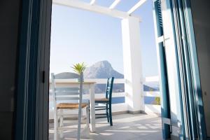 a table and chairs on a balcony with a view of the ocean at climbers village in Kalymnos