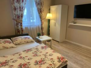 Un pequeño dormitorio con una cama y un televisor. en Apartament Romantic, en Oświęcim