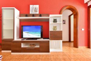 A television and/or entertainment centre at Jacuzzi & Garden Holiday Home