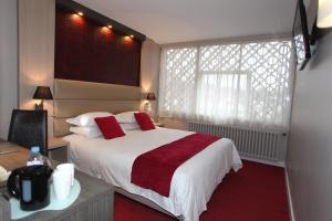 um quarto de hotel com uma cama e uma janela em Hôtel Les Trois Roses, Meylan Grenoble The Originals Boutique em Meylan