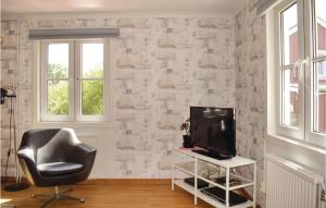 a living room with a chair and a television at Amazing Home In Bolmsö With Lake View in Bolmstad