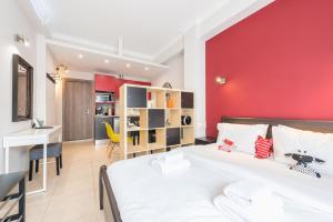 ein Schlafzimmer mit einem weißen Bett und einer roten Wand in der Unterkunft Let me Athens you! in Athen