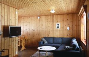 ein Wohnzimmer mit einem blauen Sofa und einem TV in der Unterkunft 2 Bedroom Stunning Home In Sysslebck in Sysslebäck