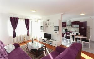 3 Bedroom Lovely Apartment In Gata في Gata: غرفة معيشة مع أريكة أرجوانية وطاولة