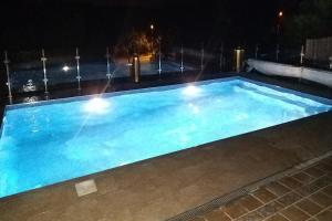 una gran piscina azul por la noche en Villa Trevali wonderful views STUNNING PRIVATE POOL heated free oct till may, en Villacosta