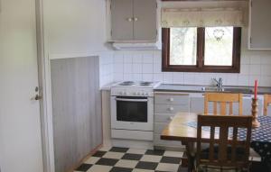 a kitchen with a table and a stove and a sink at Beautiful Home In Lidhult With Kitchen in Torarp