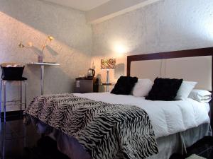 a bedroom with a large bed with a zebra blanket at Hotel Iris in Salta