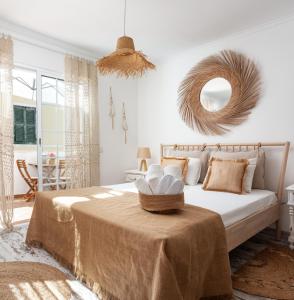 a bedroom with a bed with a table and a mirror at CASA DO SOL by Ammonite&Co in Olhão