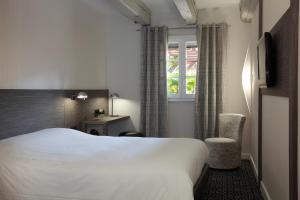 A bed or beds in a room at Hotel Restaurant Père Benoît