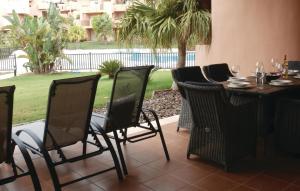 um pátio com uma mesa e cadeiras e uma piscina em Beautiful Apartment In Torre-pacheco With 2 Bedrooms, Wifi And Outdoor Swimming Pool em Los Martínez
