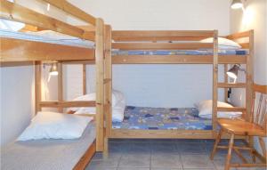 a bedroom with two bunk beds and a chair at Amazing Apartment In Ystad With Wifi in Ystad