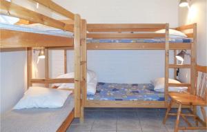 a bedroom with two bunk beds and a chair at Awesome Apartment In Ystad With 2 Bedrooms And Wifi in Ystad