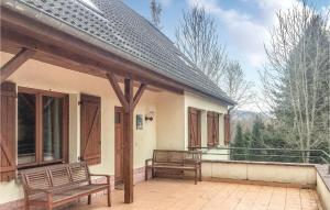 2 bancs assis sur la terrasse couverte d'une maison dans l'établissement 6 Bedroom Beautiful Home In Dirbach, à Dirbach