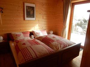 um quarto com uma cama num chalé de madeira em KRETZSCHMAR´S HÜTTE em Hochrindl