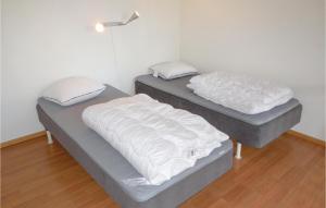 two beds in a room with white sheets at Amazing Apartment In Ystad With Wifi in Ystad +2 photos
