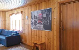 a living room with a blue couch and a red bus on the wall at Nice Home In Sysslebäck With Kitchen in Sysslebäck +7 photos