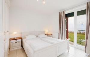 Un dormitorio blanco con una cama y una ventana grande. en Awesome Apartment In Rechlin With Sauna, en Rechlin