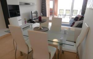 a dining room with a glass table and white chairs at Beautiful Apartment In Torre-pacheco With 2 Bedrooms, Wifi And Outdoor Swimming Pool in Los Martínez