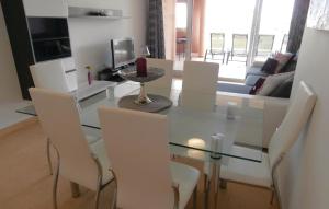 a dining room with a glass table and white chairs at Cozy Apartment In Torre-Pacheco in Los Martínez +7 photos