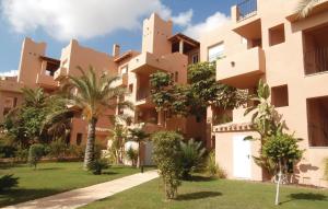 a building with palm trees in front of it at Cozy Apartment In Torre-Pacheco in Los Martínez