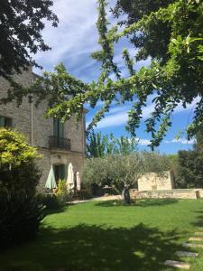 a house with a yard with green grass and trees at Les Fontaines du Mas des Fontaines in Montagnac