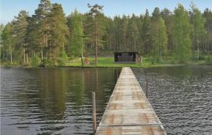 a dock in the middle of a lake with a cabin at Awesome Home In Hestra With 2 Bedrooms And Wifi in Valdshult
