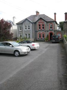 un grupo de autos estacionados frente a una casa en Dun Aoibhinn Guest Accommodation en Galway