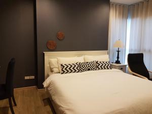 a bedroom with a large white bed with two pillows at Rain Cha-am Huahin by Smiley in Cha Am +19 photos