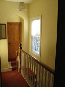 pasillo con escalera, ventana y ventana en Dun Aoibhinn Guest Accommodation, en Galway