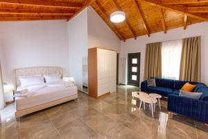 クサミルにあるSanta Oliva Suitesのベッドルーム1室(ベッド1台、ソファ、テーブル付)