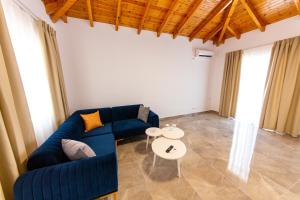 a living room with a blue couch and a table at Santa Oliva Suites in Ksamil