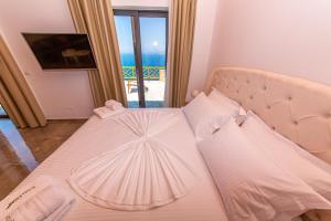 a bed in a room with a view of the ocean at Santa Oliva Suites in Ksamil