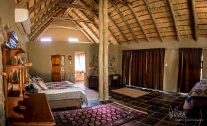 sypialnia z łóżkiem w pokoju z drewnianym sufitem w obiekcie Rio Dos Elefantes River Camp w mieście Hoedspruit