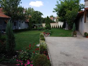 un jardín con flores rosas en un patio en Apartman Vila Milica en Kikinda