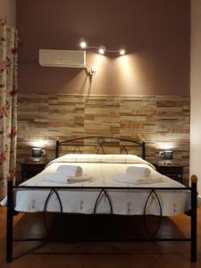 1 dormitorio con cama blanca y pared de madera en Kefallonia Bay Resort en Spartia