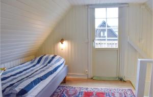 a small bedroom with a bed and a window at Nice Home In Hllviken With 2 Bedrooms in Höllviken